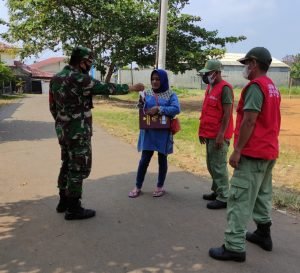 Wujud Kepedulian, Babinsa Serma Ari Bersama Linmas Bagikan Masker Gratis